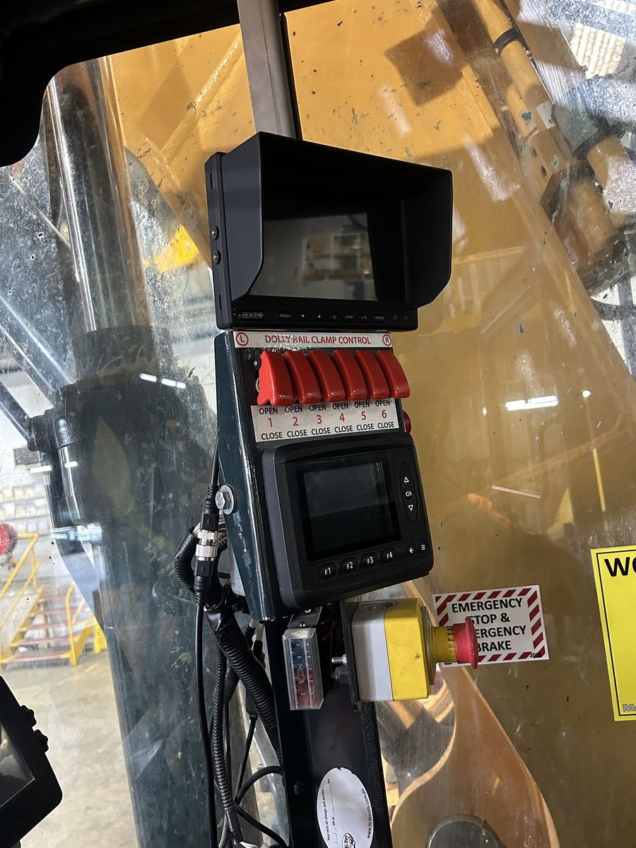 Rail clamp controls and camera monitor in a machine cab